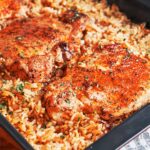 Baked Pork Chops and Rice with juicy golden pork chops over savory, fluffy rice finished with fresh parsley.