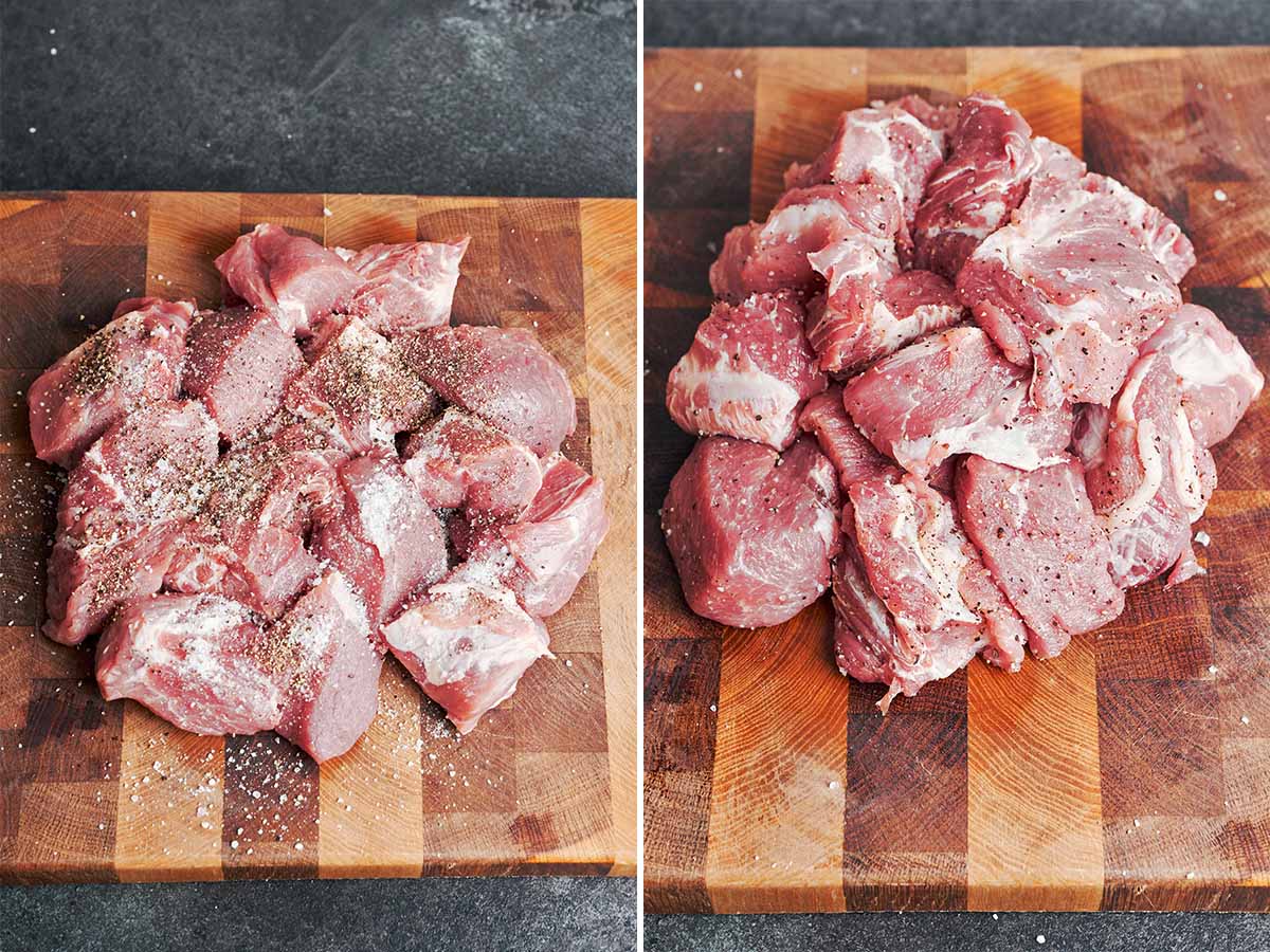 Chunks of pork shoulder seasoned with salt and black pepper on a wooden cutting board, ready for browning.