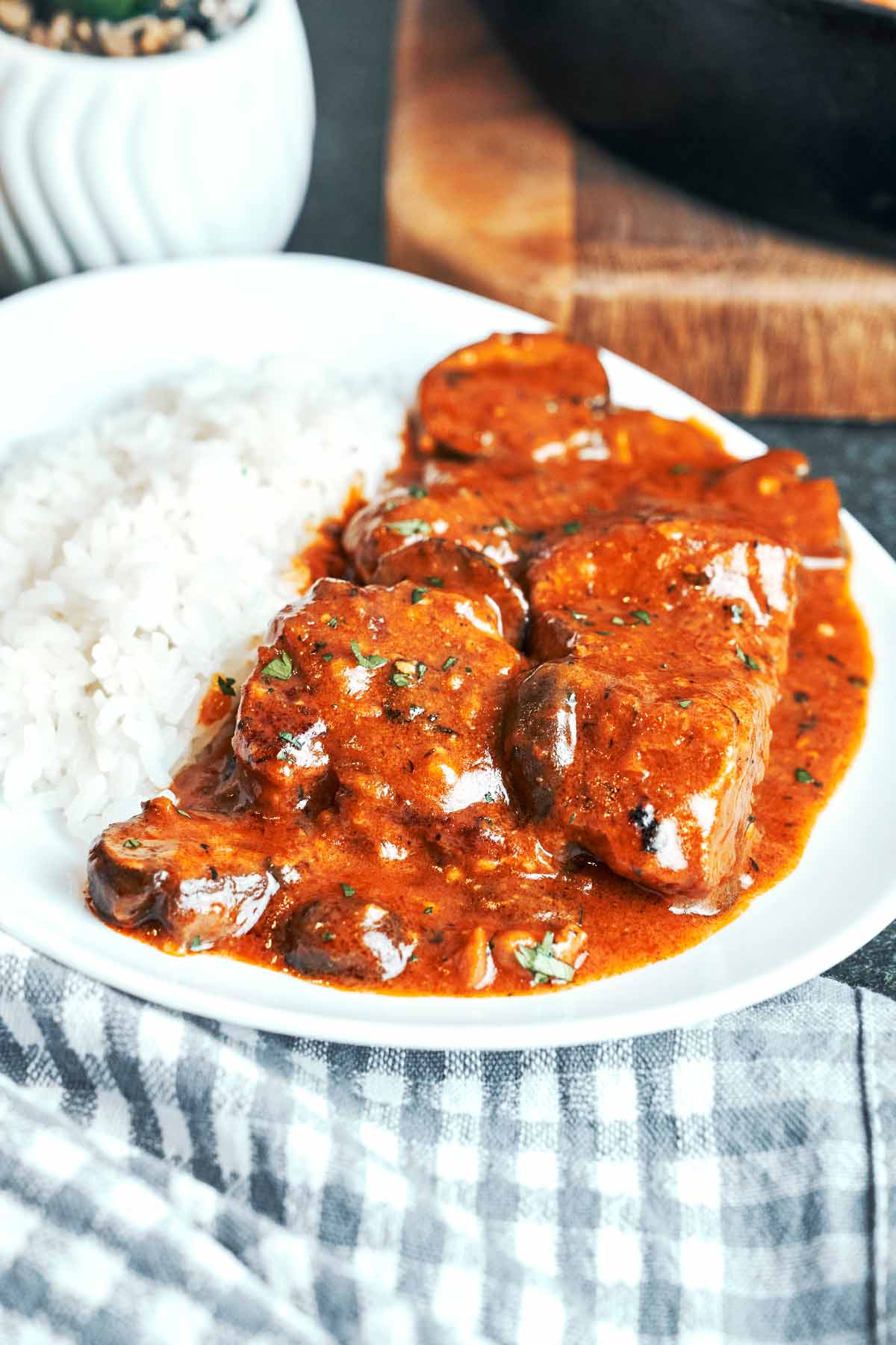 Pork and mushrooms in rich gravy spooned alongside fluffy white rice, with a sprinkle of parsley on top.